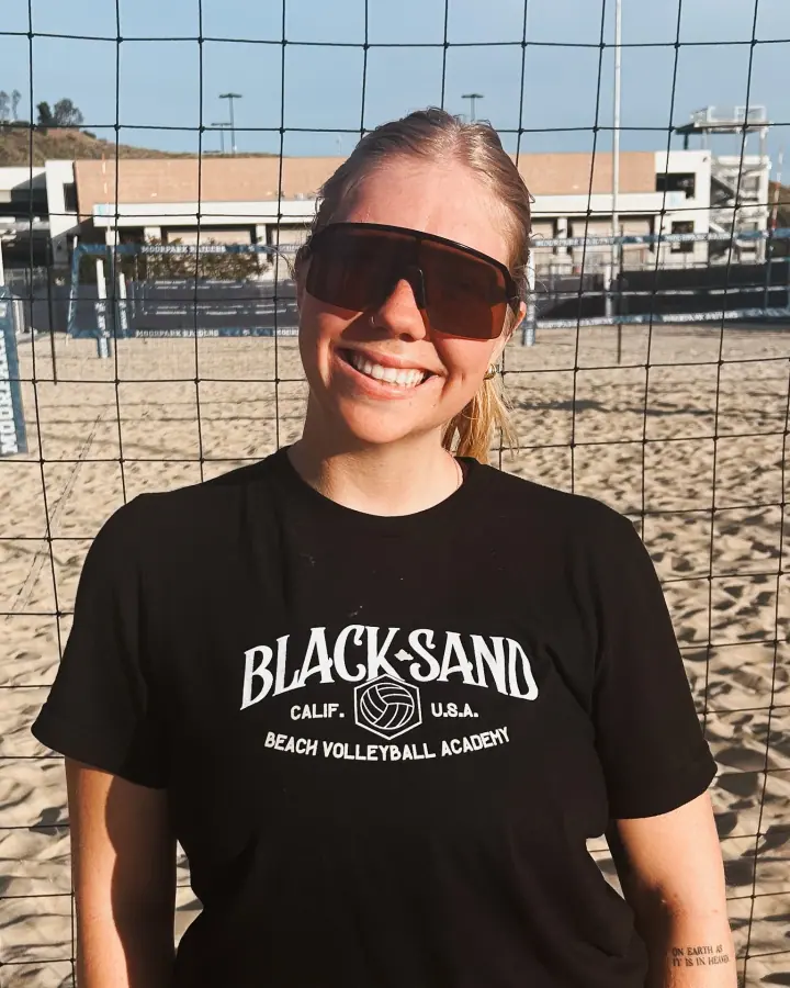 Coach Cambria Giordano at the net in a Black Sand shirt