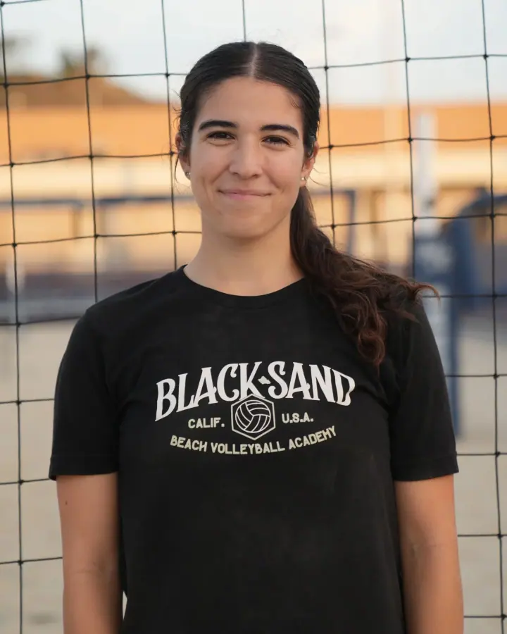 Coach Ela Lagattuta at the net in a Black Sand shirt