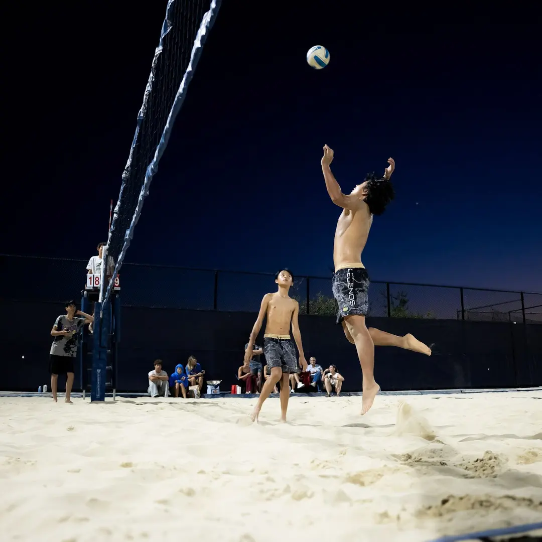 A player jumps to hit at dusk