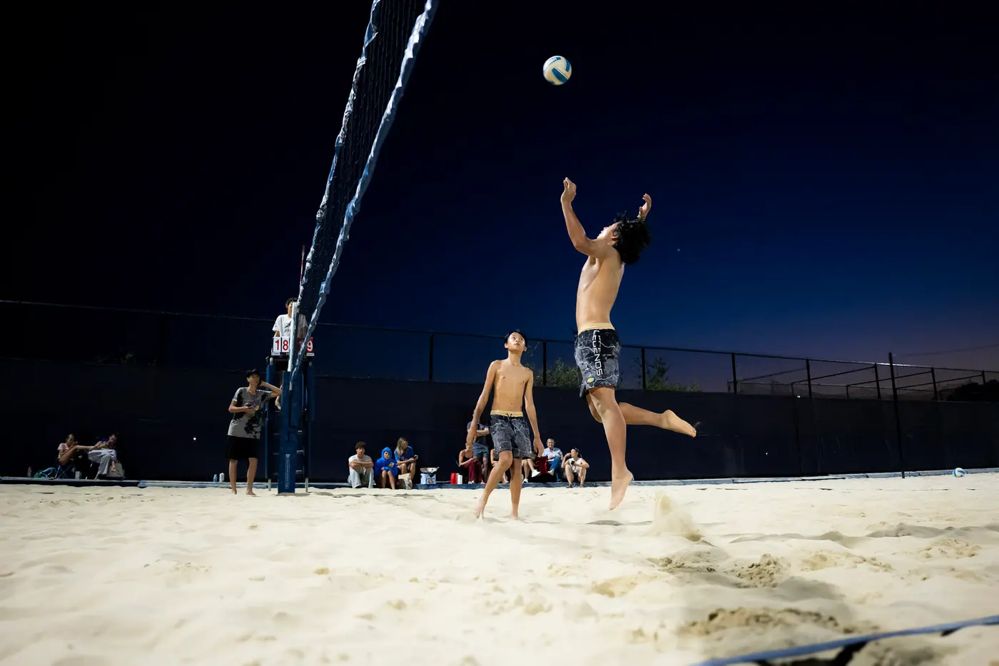 A player leaps to attack as the sun sets
