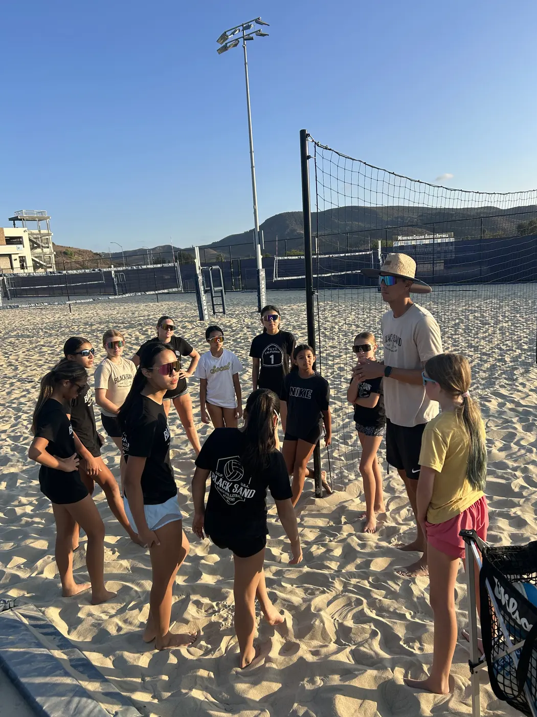 The group gathers on the sand at sunset