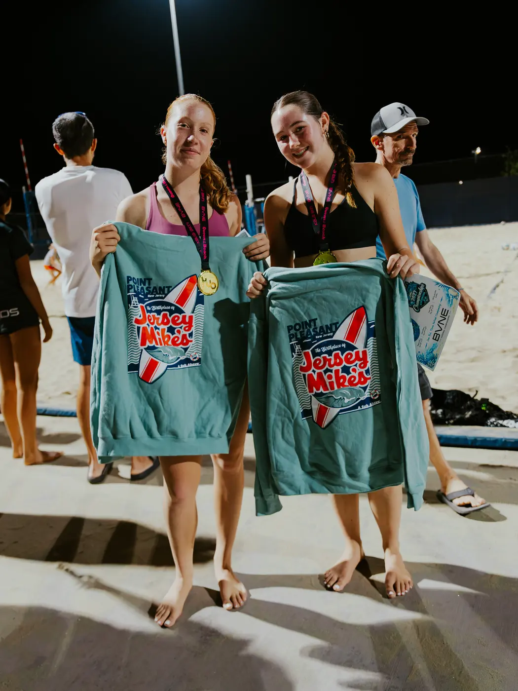 Players hold up their prize sweatshirts