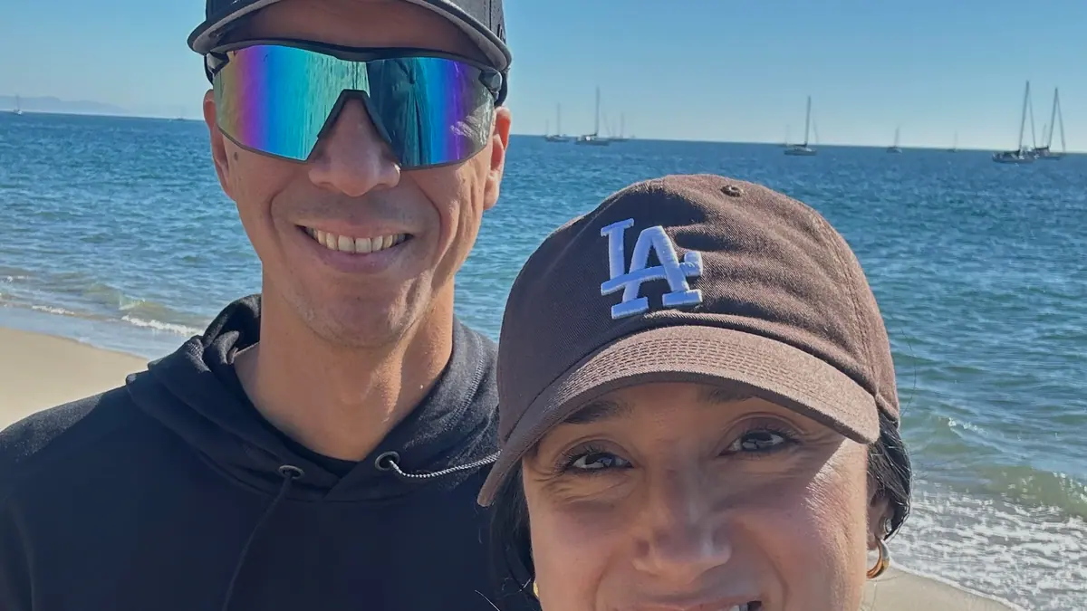 Adam and Crystal Black smile on the beach in Black Sand hoodies