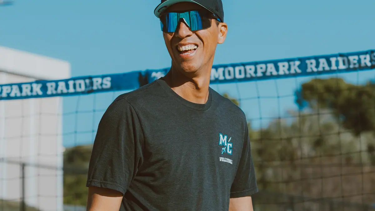 Coach Adam Black walks the sand court in front of the Moorpark Raiders windscreen